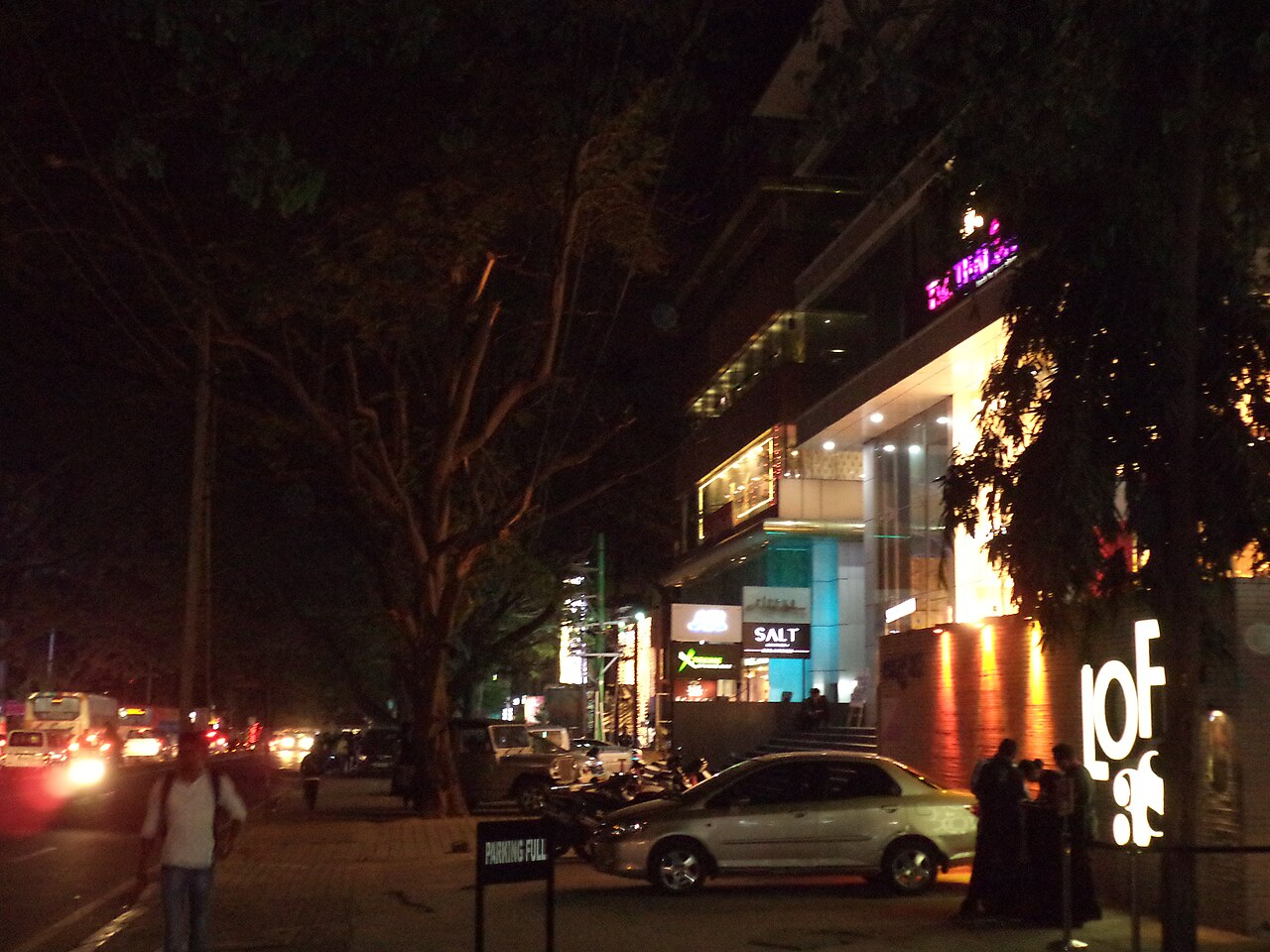 100 Feet Road in Indiranagar at night, shops and lights along the street